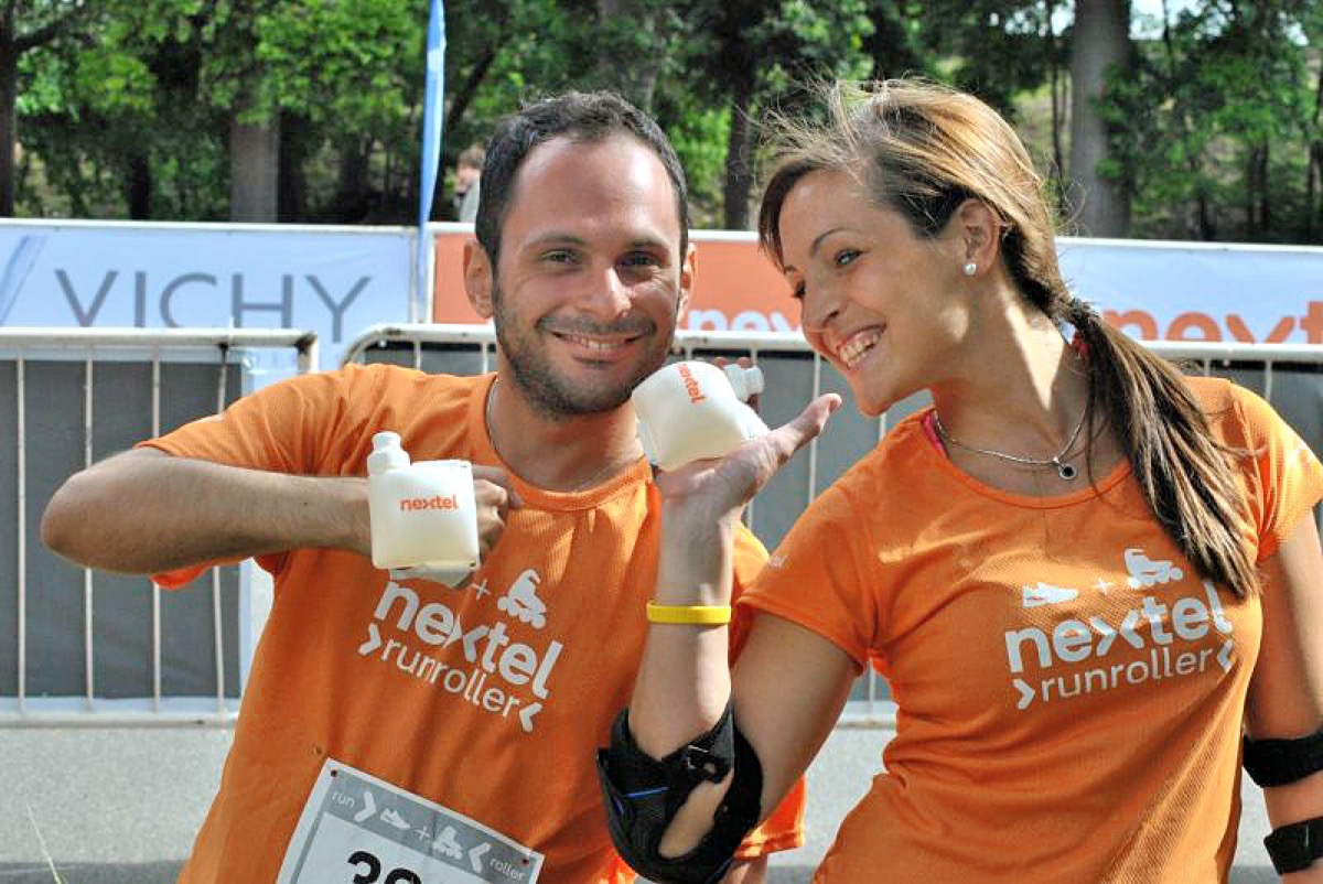 Two runners wearing Nextel-branded Swiggies wrist water bottles at the Nextel RunRoller race