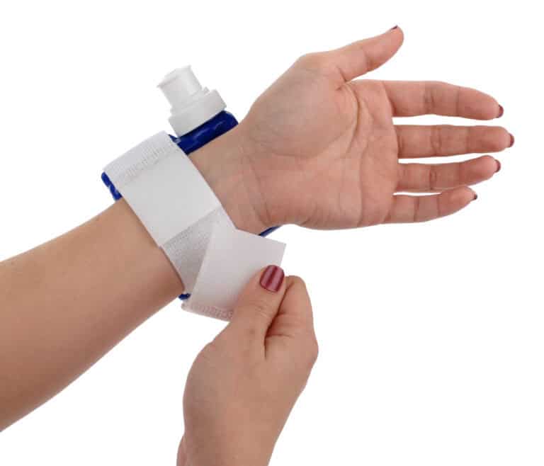 A reusable Swiggies wrist water bottle being strapped onto a wrist
